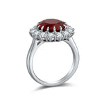 Load image into Gallery viewer, Silver ring featuring a prominent oval red gemstone surrounded by smaller white gemstones.
