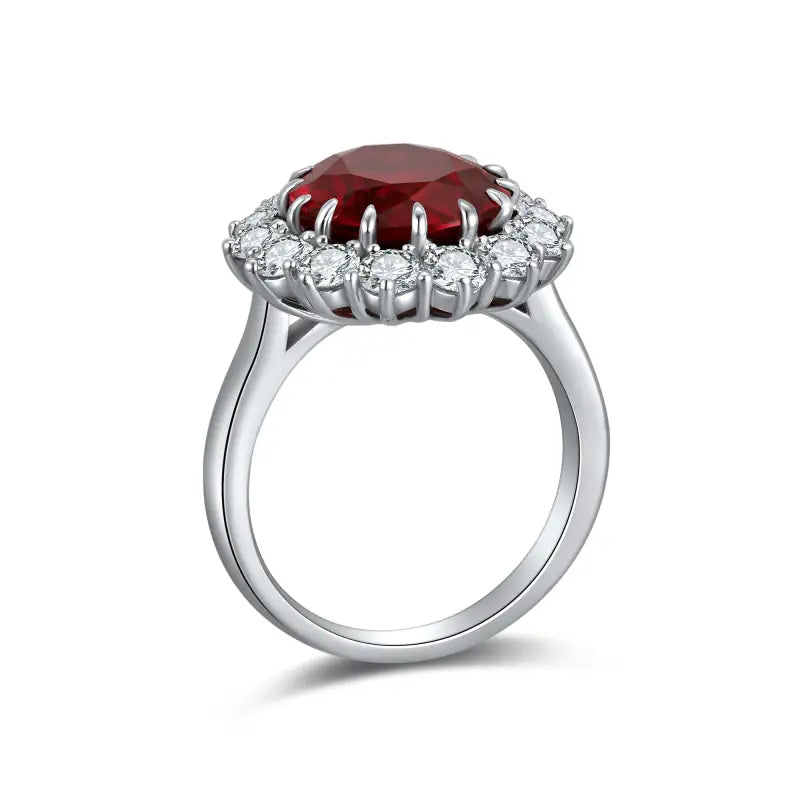 Silver ring featuring a prominent oval red gemstone surrounded by smaller white gemstones.