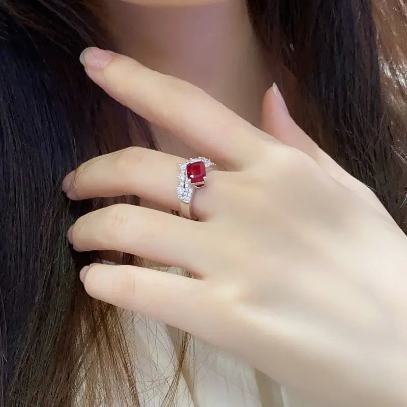 Ruby and diamond ring on a person’s finger.