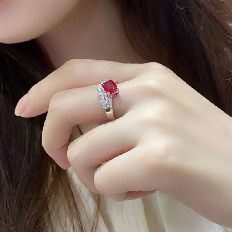 Ruby and diamond ring on a person’s finger.