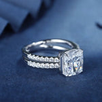 Load image into Gallery viewer, Diamond engagement ring with a prominent square-cut center stone and two pave bands.
