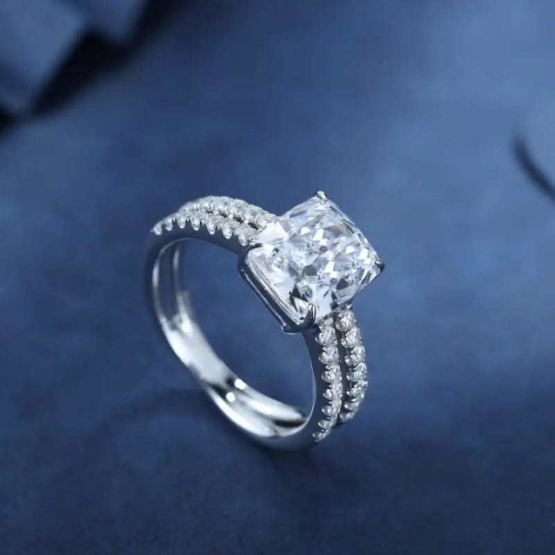 Diamond engagement ring with a cushion-cut center stone and pave-set band.