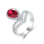 Load image into Gallery viewer, Elegant silver ring featuring a pear-shaped ruby surrounded by diamonds in a swirling design.
