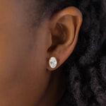 Load image into Gallery viewer, Oval-shaped diamond stud earring worn in an earlobe.
