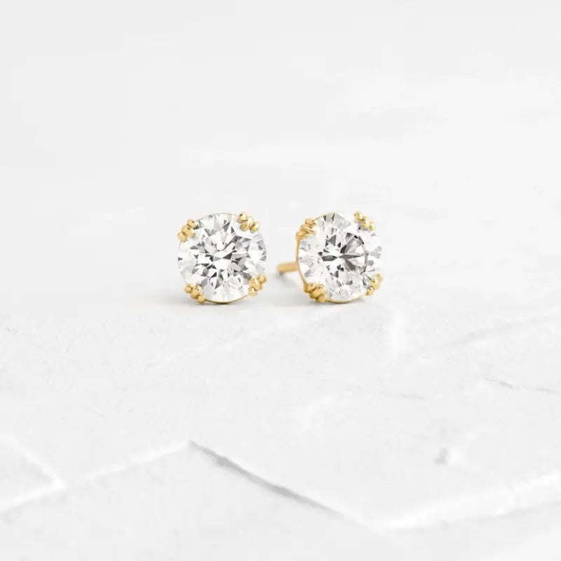 Pair of diamond stud earrings set in gold.