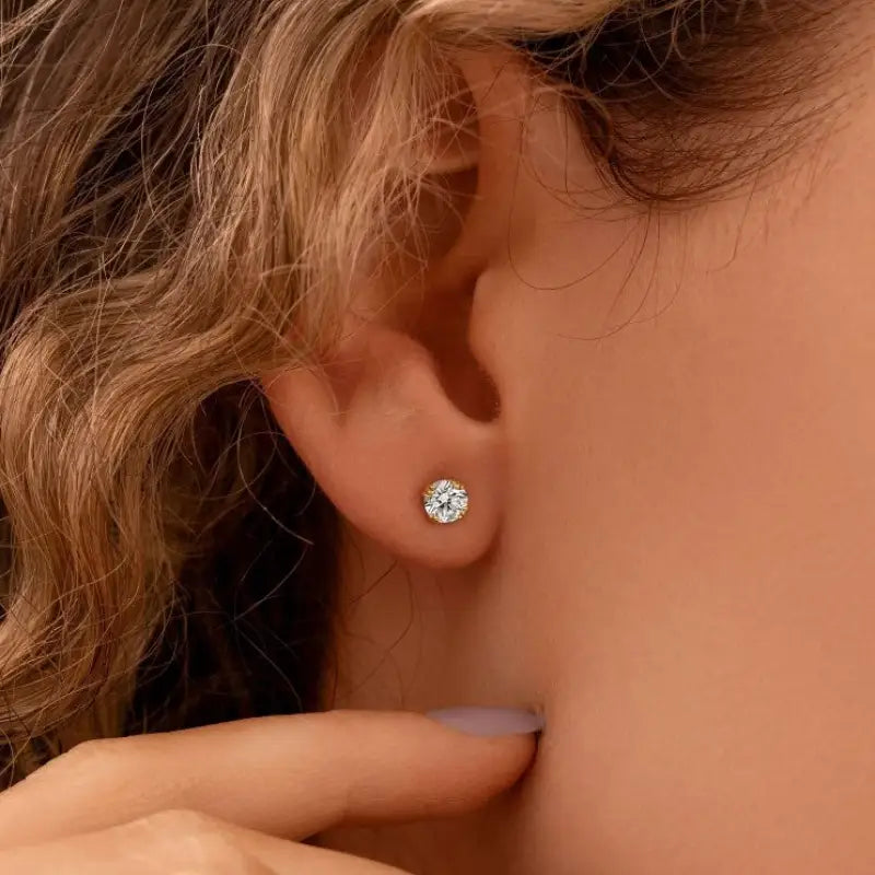 Diamond stud earring in a person’s earlobe.