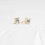 Load image into Gallery viewer, Pair of diamond stud earrings set in gold.
