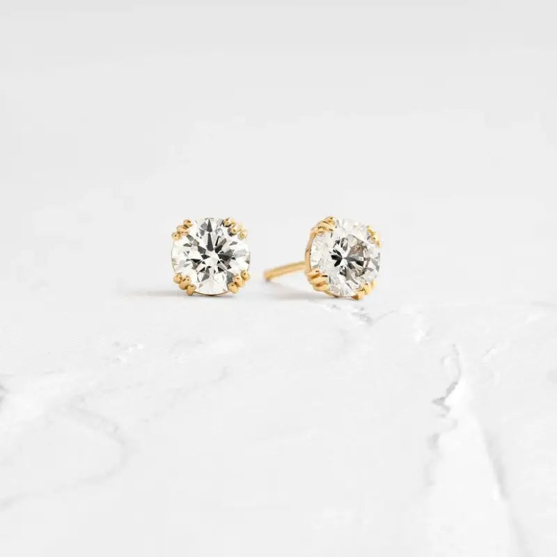 Pair of diamond stud earrings set in gold.