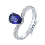 Load image into Gallery viewer, Silver ring with a pear-shaped blue gemstone and diamond accents.
