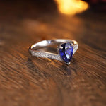 Load image into Gallery viewer, Elegant silver ring featuring a pear-shaped blue gemstone and diamond accents on the band.
